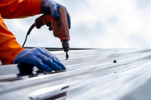 Roofer Installing Metal Sheet